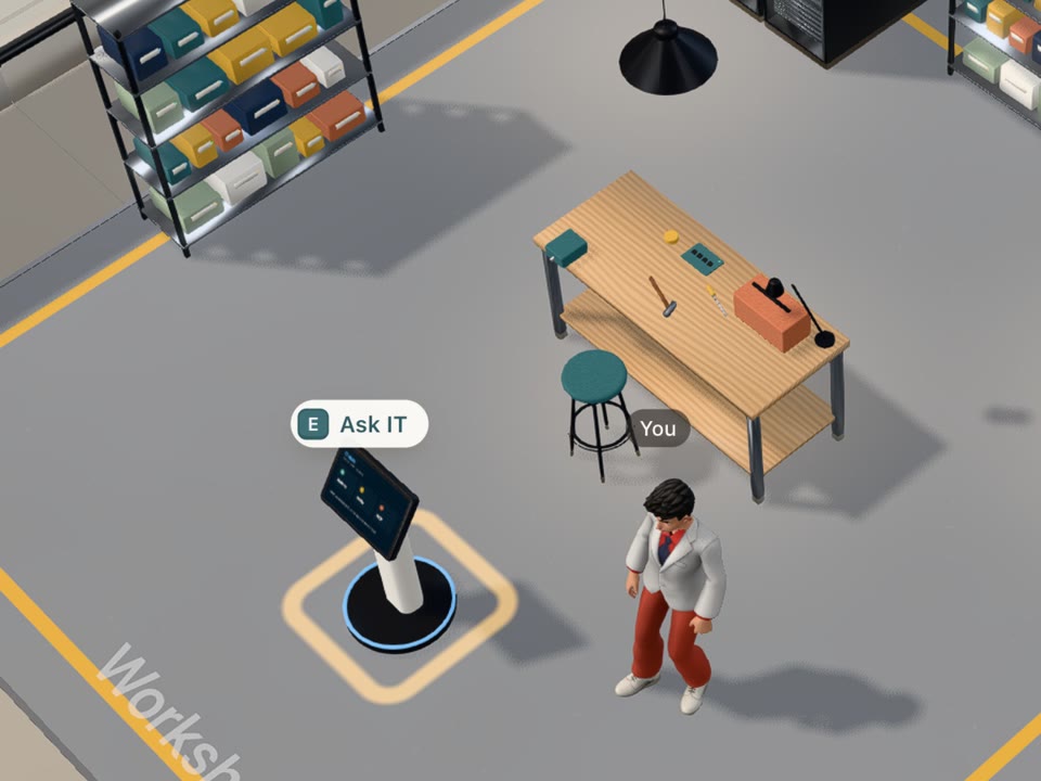 The IT kiosk in the workshop with an Ask IT prompt, next to the workbench and parts shelves
